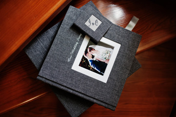 Elegant grey photo book or photo album and flash drive case on wooden stairs.