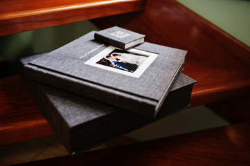 Elegant grey photo book or photo album and flash drive case on wooden stairs.