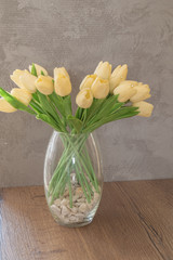 Artificial flowers in a vase on a table.
