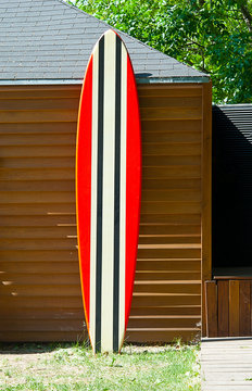 Surfboard next to the house in nature
