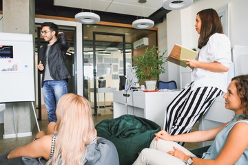 Young professional team. Group of young modern people in casual clothes having a brainstorm while...