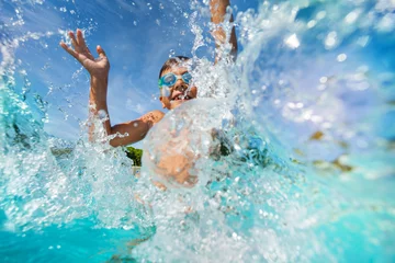 Fotobehang Happy boy playing and splashing in swimming pool © Sergey Novikov