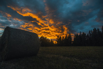 Hay bales at sunset, scenic clouds