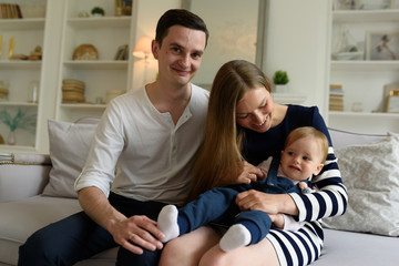 Obraz premium Happy parents playing with child at home