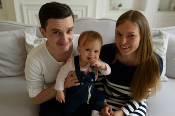 Happy parents playing with child at home