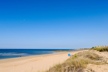 Fototapeta na wymiar Nearly empty beach on sunny day in Zahora, Cadiz province in South Spain. Low season, economic crisis, travel destination, summer vacation concepts