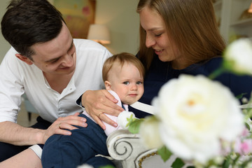 Happy parents playing with child at home