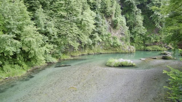 View of the Serio river, from the wooden bridge during the day,pan video with gimbal,space color bt 2020 hlg, 4k footoge.Val Seriana Bergamo.