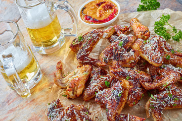chicken wings, glass cups of beer