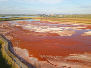 Aerial view of a reservoir full of red toxic sludge