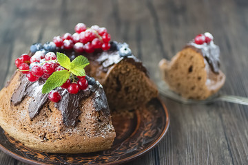 Homemade chocolate cake with chocolate icing, mint  and fresh berries.