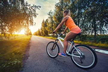 Fototapeta na wymiar cute woman cyclist cycling mountain bike on the picturesque road