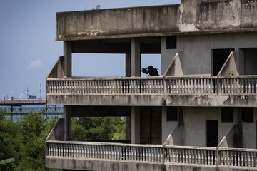 Silhouette of killer or hitman with weapons at day.