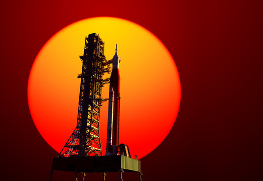Space Launch System On Launchpad On Background Of Red Sun