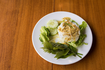Thai rice noodles with vegetables on wooden table