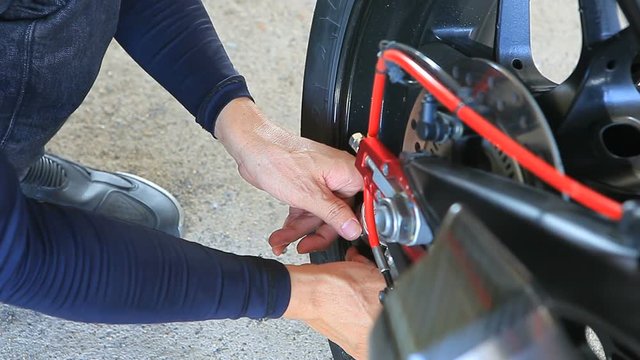 man checking motorcycle rear rubber tire