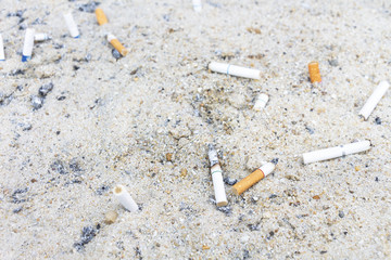 Tobacco cigarette butt on the beach sand.
