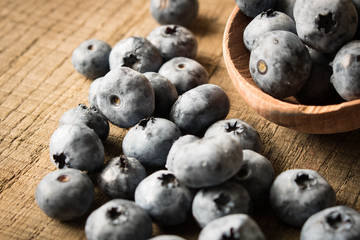 Fresh blueberries on an old wooden table in a wooden spoon. Close up. The concept of natural food