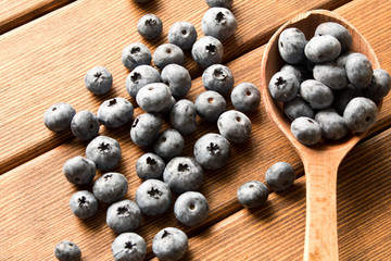 Fresh blueberries on an old wooden table in a wooden spoon. Close up. The concept of natural food