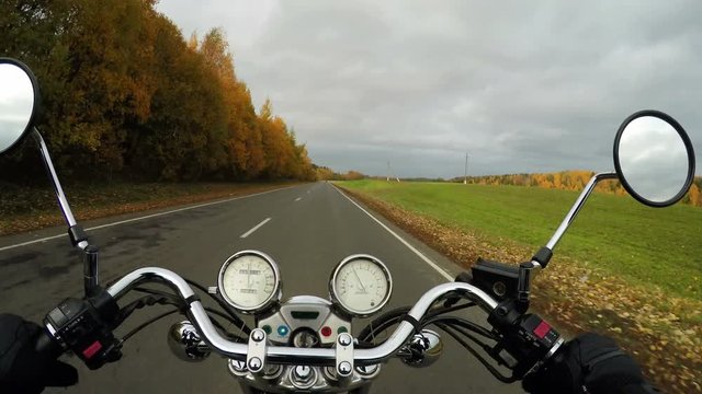 4K. Motorcycle rides on the beautiful autumn road at sunny day, wide point of view of rider. Classic cruiser/chopper forever! 