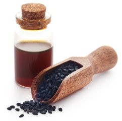 Nigella seeds and essential oil in a glass bottle