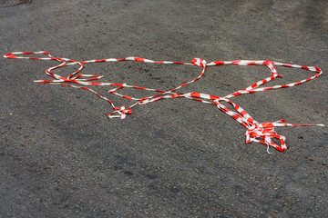 Red white protective tape carried away by the wind is lying under your feet passer-by on the...