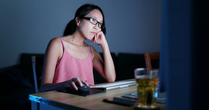 Woman feeling bored and looking at the computer