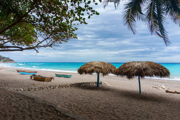 Fototapeta na wymiar sandy beach with umbrellas near the azure Caribbean sea