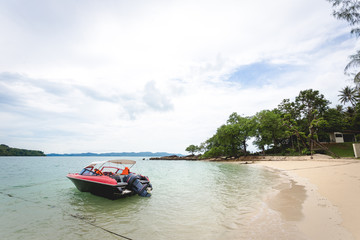 Fototapeta na wymiar red private small speed boat parking near seaside of island