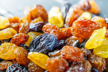 Assortment of Raisins, yellow, blue, black, golden raisin on dark background. Healthy snack,...