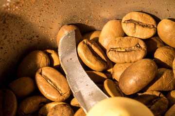 Macro photo of freshly ground coffee in electric coffee grinder with roasted coffee beans inside and coffee grains close-up view of the top.