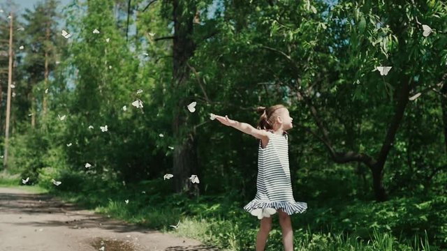 Young girl in nature holding a rice paper butterfly