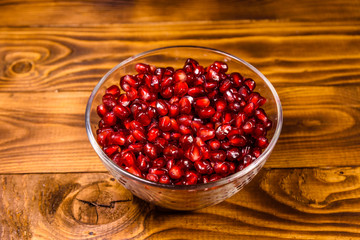 Seeds of the garnet fruit in glass bowl on wooden table