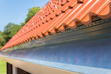 Close up new gutter with roof tiles
