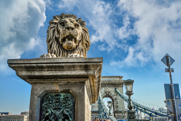 A stone lion stands at the entrance to the Chain Bridge on the Buda side of the Danube in Budapest,...