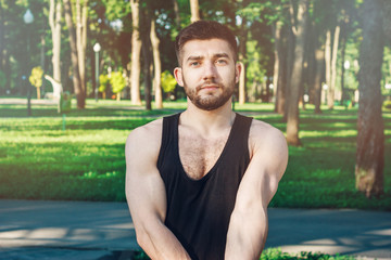 Obraz premium Handsome young bearded male athlete exercising in a city park early morning