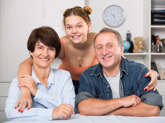 Portrait of marrieds with their adult daughter at the table