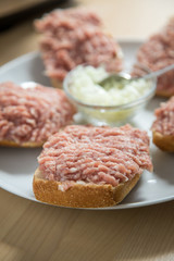 Teller mit 5 Mettbrötchen mit Schweinemett und Zwiebeln auf Küche Arbeitsfläche