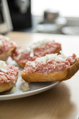Teller mit 5 Mettbrötchen mit Schweinemett und Zwiebeln auf Küche Arbeitsfläche