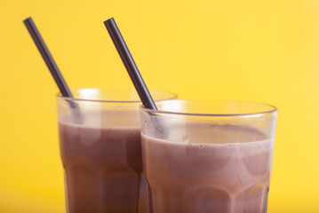 Chocolate Coccoa Sweet Drink Glass Straw Isolated Yellow Background Selective focus.