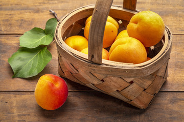 basket of ripe apricot on rustic wood