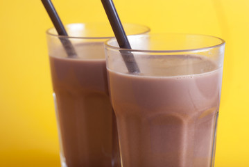 Chocolate Coccoa Sweet Drink Glass Straw Isolated Yellow Background Selective focus.