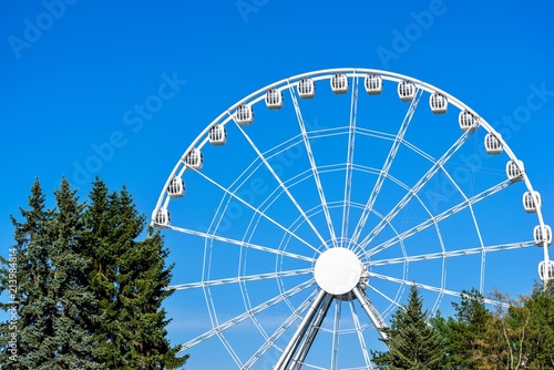 White Big Ferris Wheel With Cabins Against The Background Of The