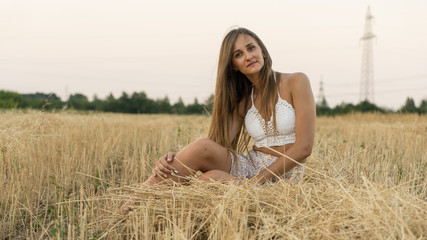 Fototapeta na wymiar the girl is sitting in a crooked field