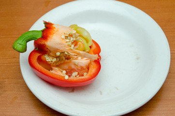 red pepper lies on a plate, pepper with seeds