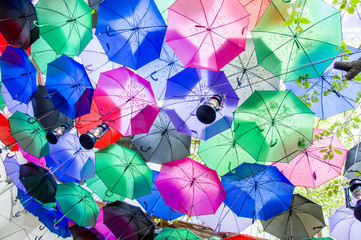 umbrellas hanging above the head with lamps, in the open air