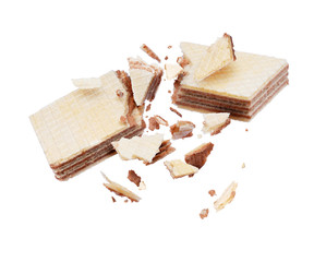 Chocolate waffle crushed into pieces in the air on a white background