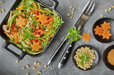 Spaghetti from zucchini. Raw food diet: uncooked spaghetti zucchini with paprika, carrots, pine nuts and fresh Basil