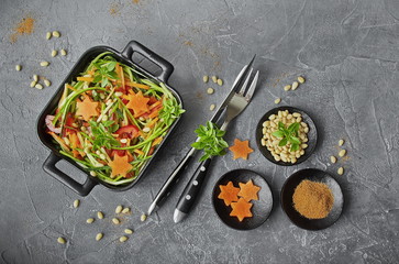 Spaghetti from zucchini. Raw food diet: uncooked spaghetti zucchini with paprika, carrots, pine nuts and fresh Basil