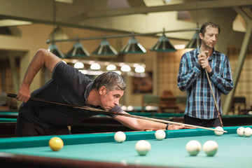 the player takes aim at the ball in Billiards